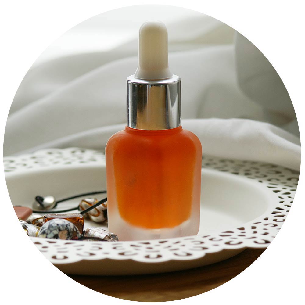Orangefarbenes, klares Granatapfelgesichtssöl in einer Pipettenflasche aus satiniertem Glas