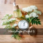 Olionatura-Seminar Modul I: Emulsion im Glastiegel und Serumflasche mit Blüten auf einem Holztisch